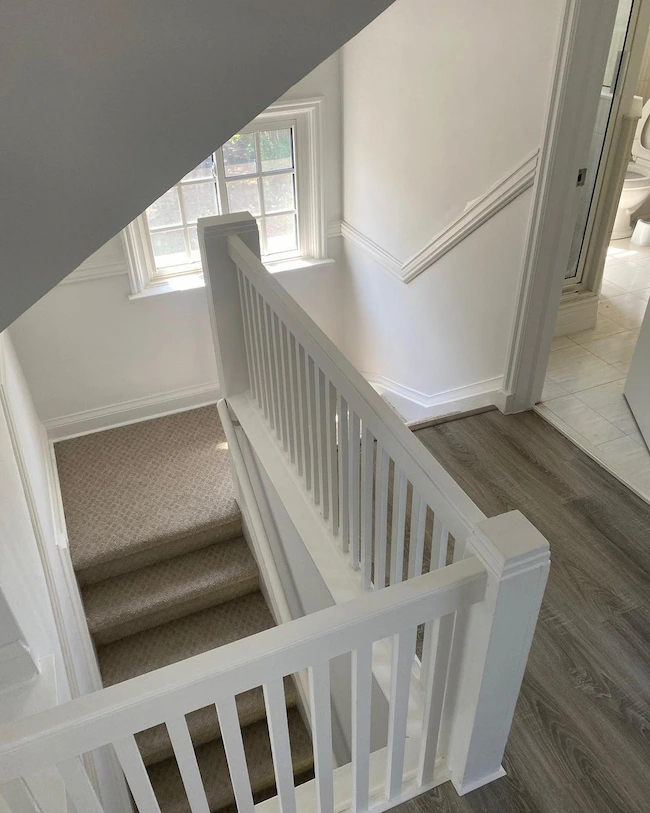 A staircase restored by Tekora Home with a white railing